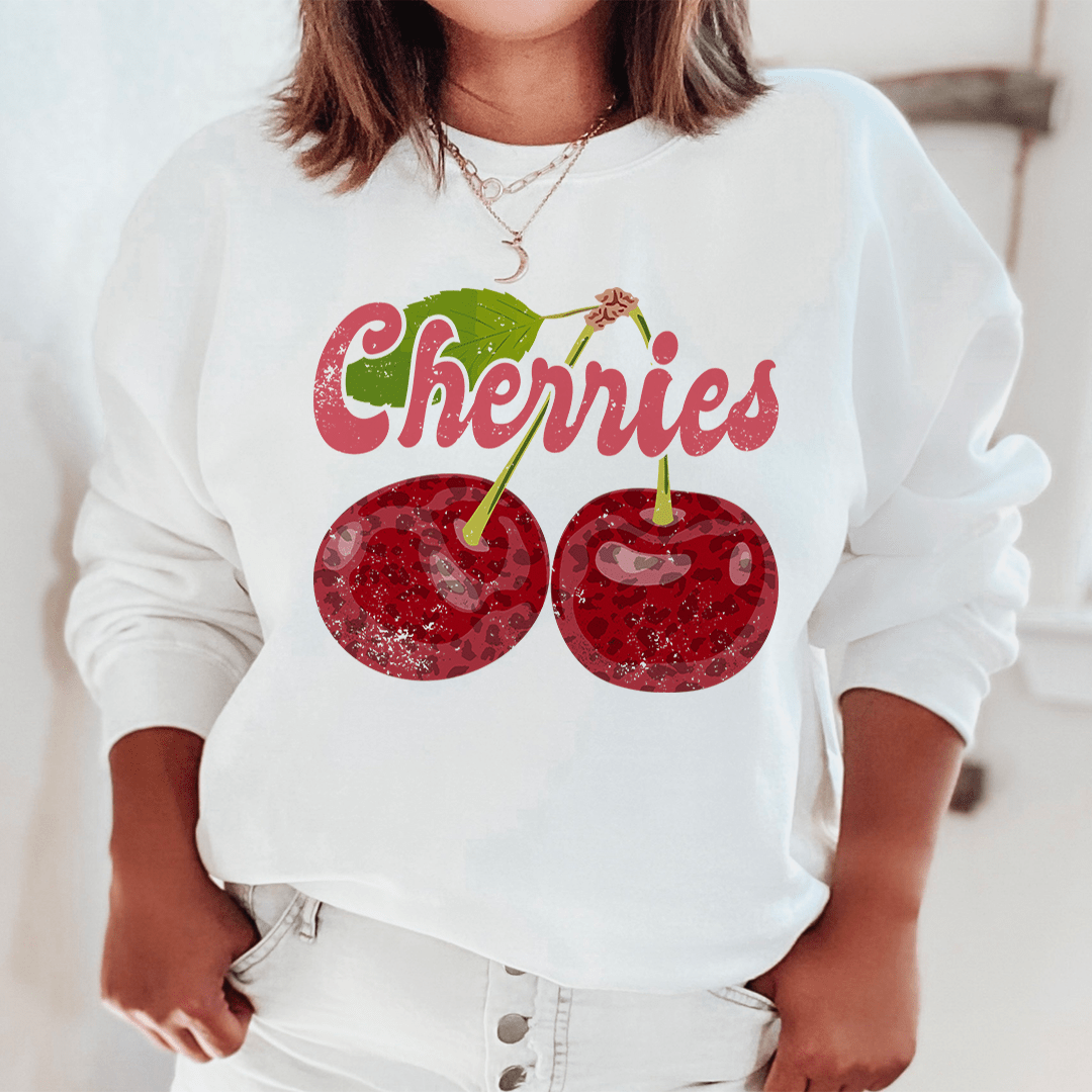 A cozy Cherries hoodie made from cotton/poly fleece blend, featuring adjustable banded cuffs and unique artistic designs.