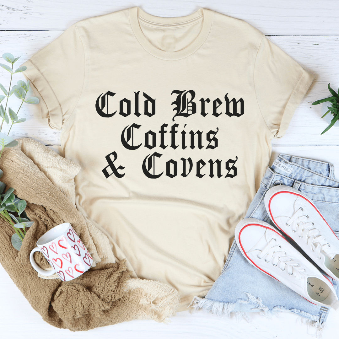 Cold Brew Coffins & Covens Tee featuring a spooky Halloween design, made from 100% soft cotton, perfect for festive celebrations.