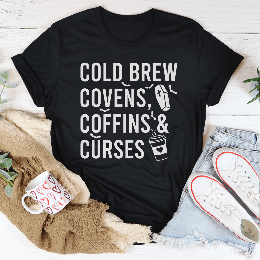 Cold Brew Covens Coffins Curses Tee featuring a spooky Halloween design on soft cotton fabric.