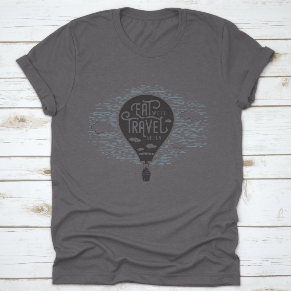 A whimsical t-shirt featuring a cupcake riding a balloon in the sky with clouds, showcasing a playful and colorful design.
