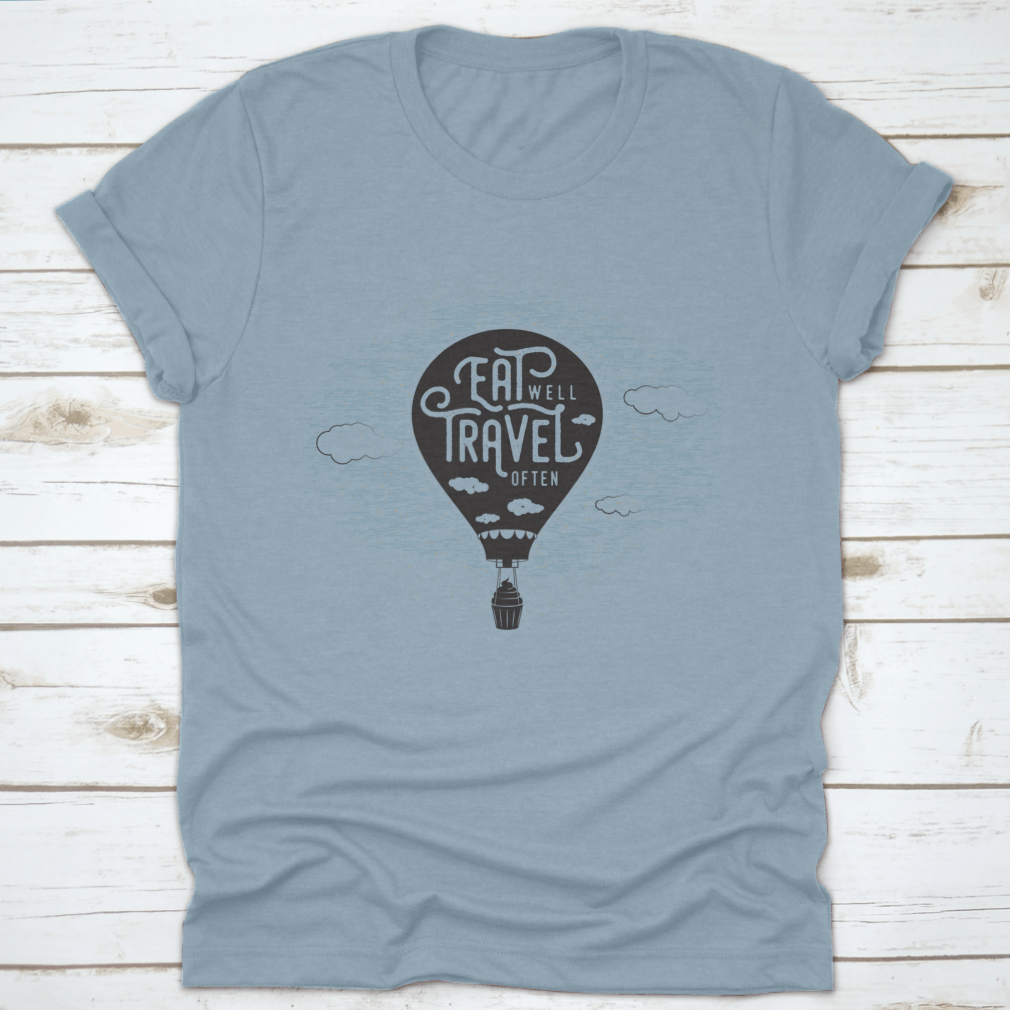 A whimsical t-shirt featuring a cupcake riding a balloon in the sky with clouds, showcasing a playful and colorful design.