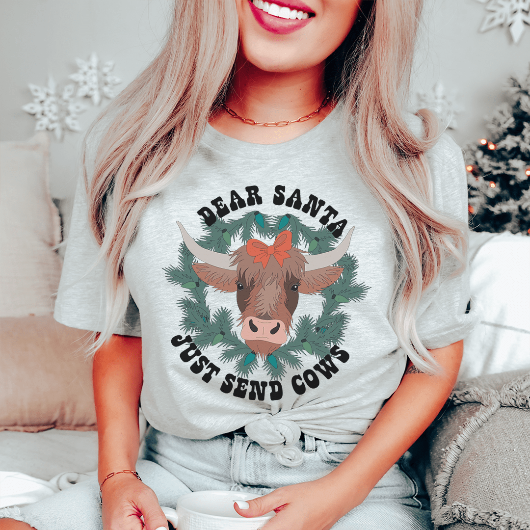 A festive Dear Santa Just Send Cows Tee made from 100% soft cotton, featuring a playful holiday design.