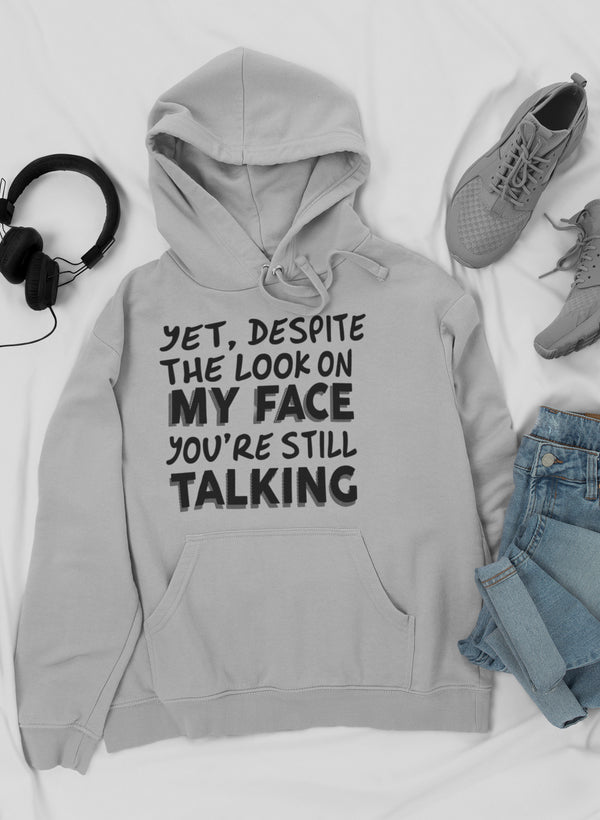 A stylish hoodie featuring the phrase 'Despite The Look On My Face You're Still Talking', designed by top artists, showcasing a cozy fleece material.