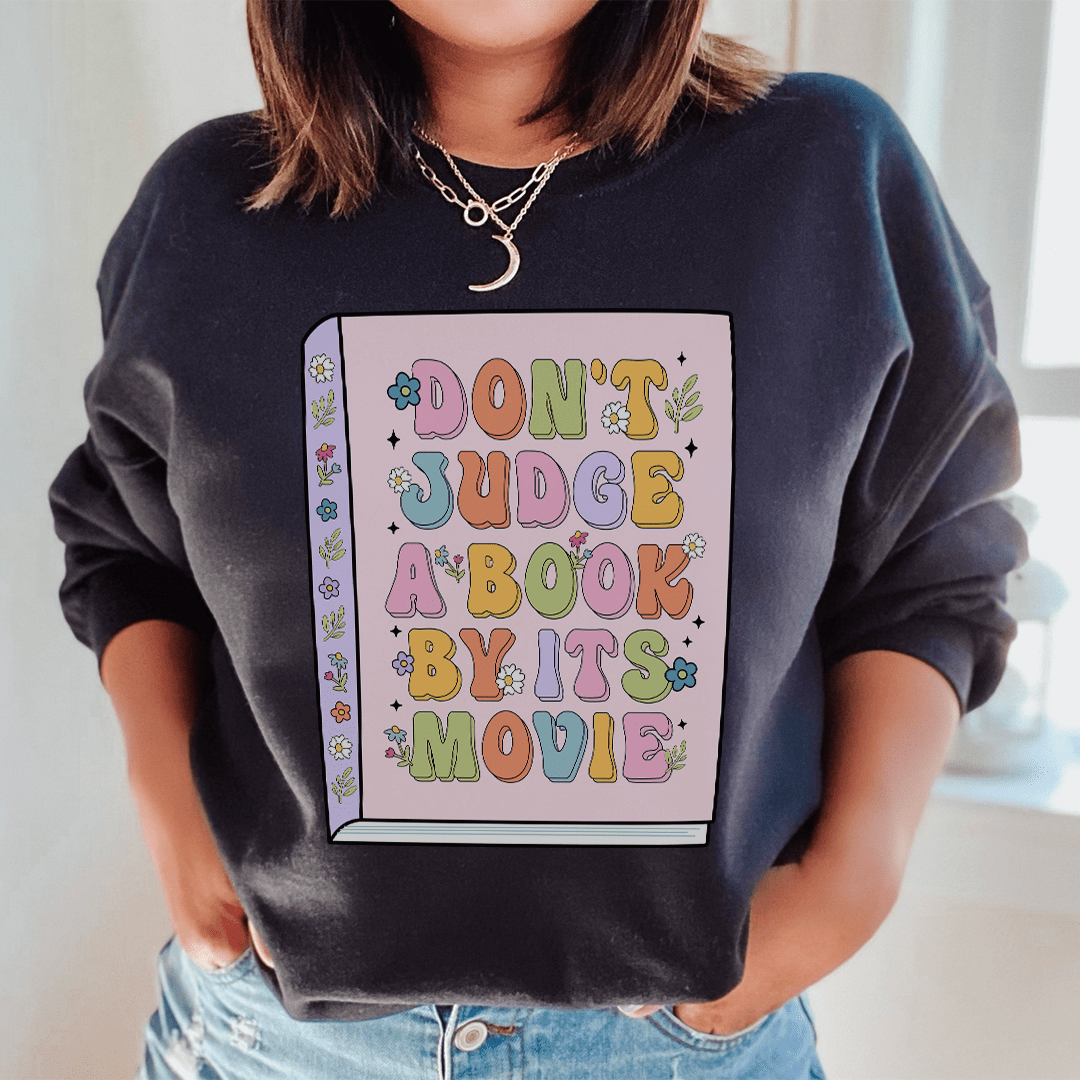 A cozy 'Don't Judge A Book' hoodie featuring unique artistic designs, made from a cotton/poly fleece blend for warmth and comfort.