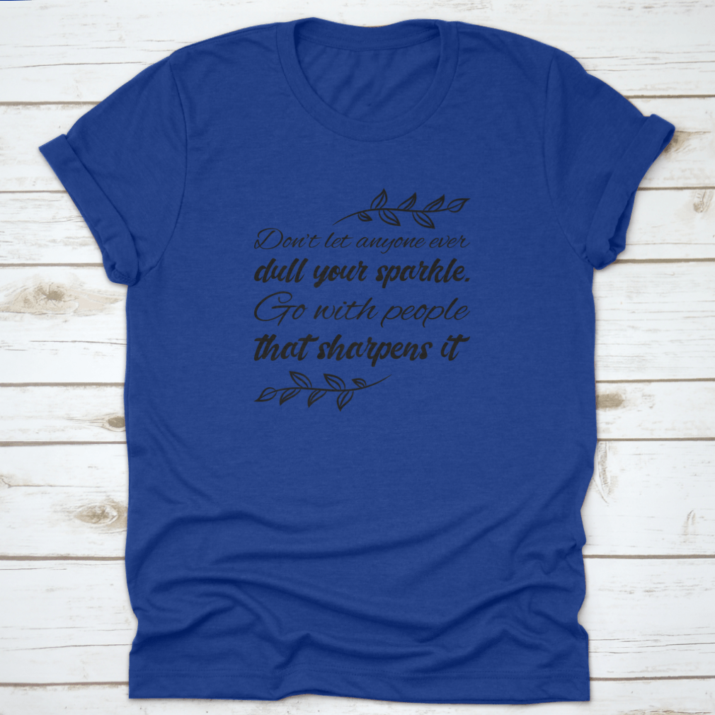 A stylish t-shirt featuring the quote 'Don’t Let Anyone Dull Your Sparkle' in a vibrant design, made from 100% cotton.