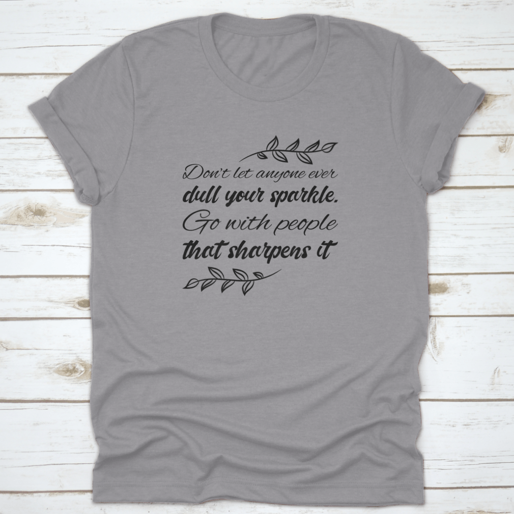 A stylish t-shirt featuring the quote 'Don’t Let Anyone Dull Your Sparkle' in a vibrant design, made from 100% cotton.