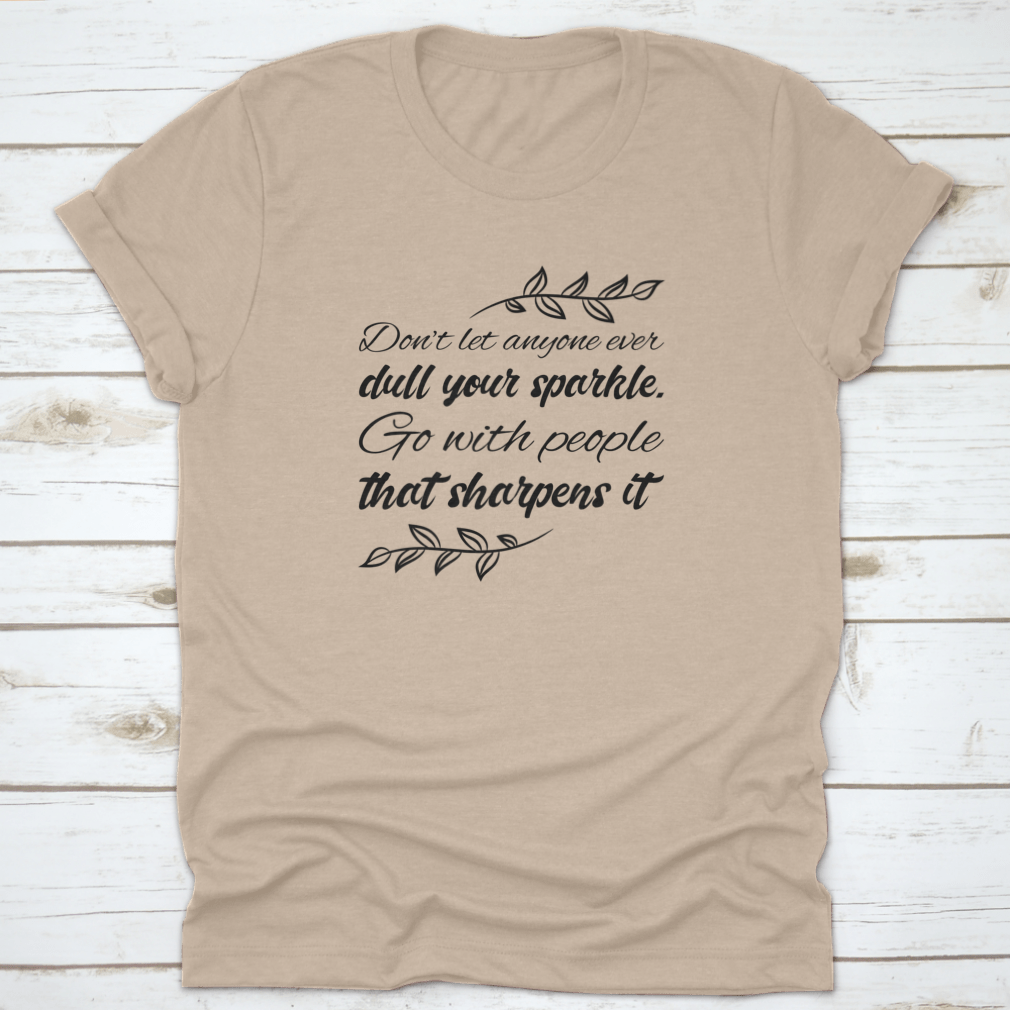 A stylish t-shirt featuring the quote 'Don’t Let Anyone Dull Your Sparkle' in a vibrant design, made from 100% cotton.
