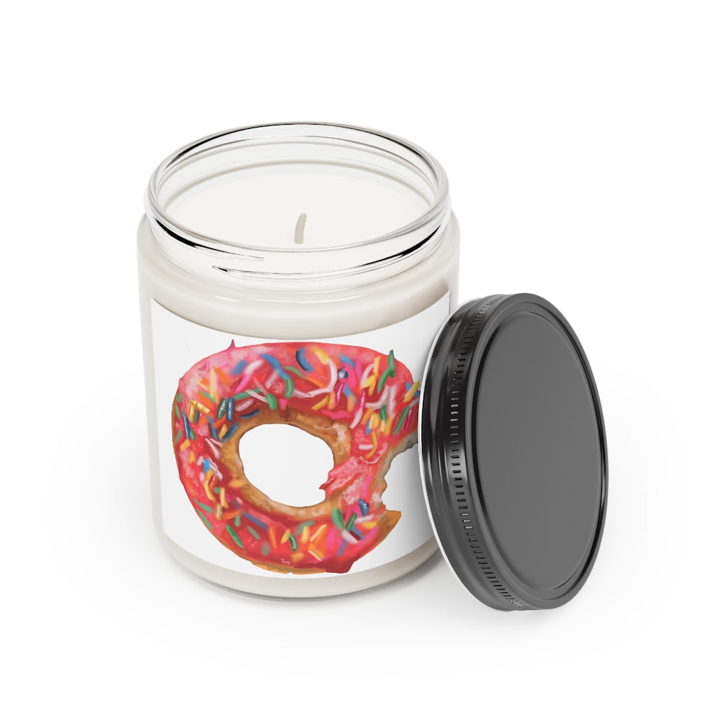A beautifully hand-poured Donut Scented Candle in a glass container, featuring a permanent adhesive label and available in Cinnamon Stick and Vanilla fragrances.