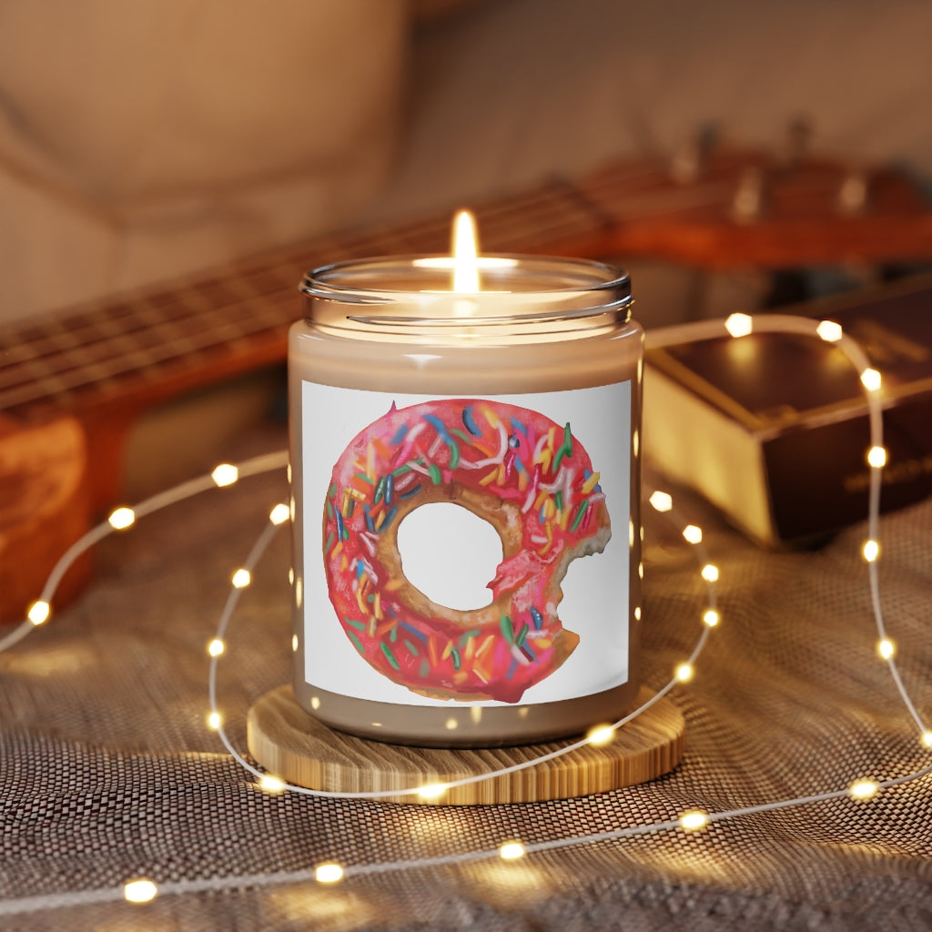 A beautifully hand-poured Donut Scented Candle in a glass container, featuring a permanent adhesive label and available in Cinnamon Stick and Vanilla fragrances.