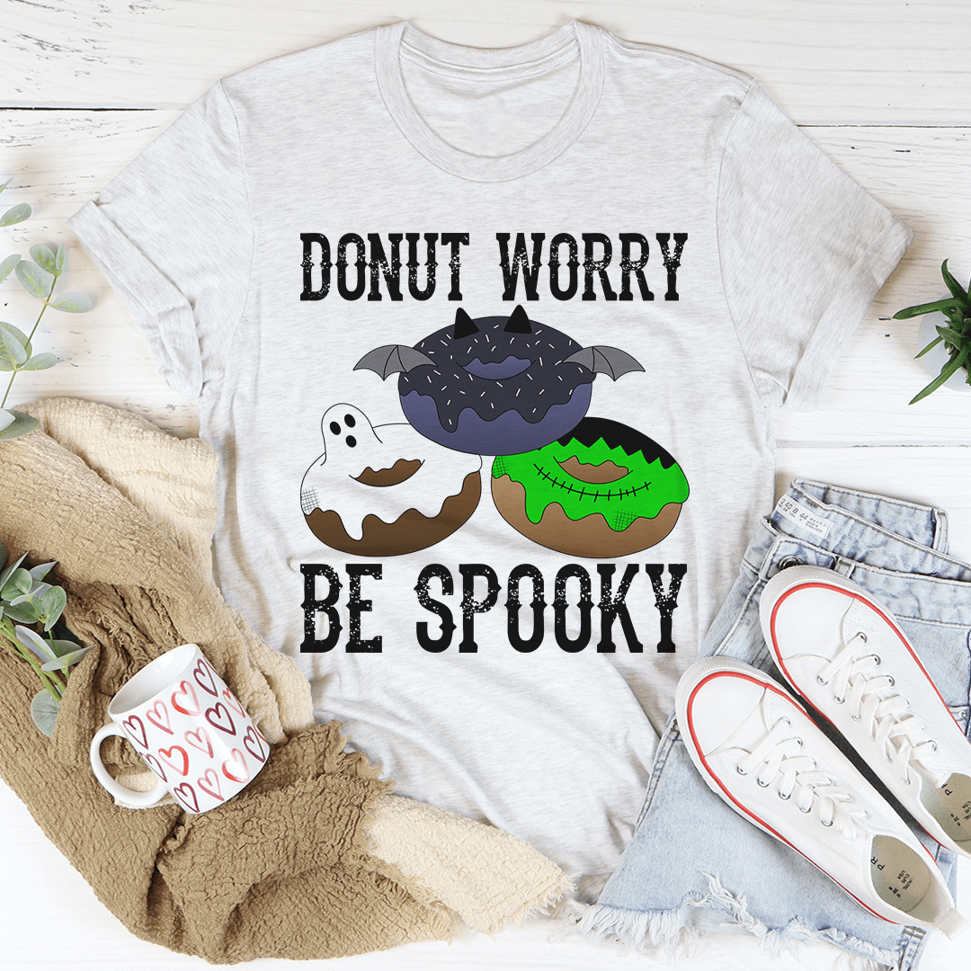A cozy Donut Worry Be Spooky T-Shirt featuring a playful Halloween design, made from soft ring-spun cotton with double stitching for durability.