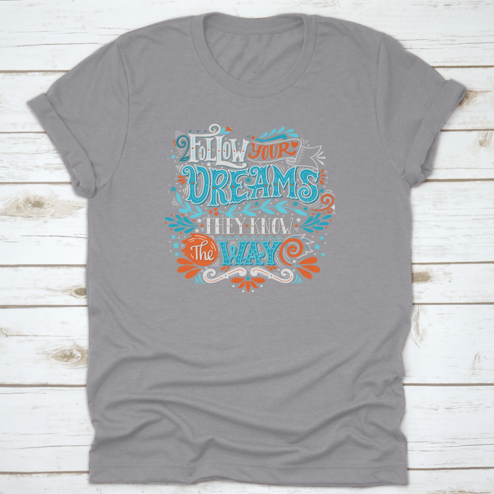 A hand-drawn inspirational quote T-shirt featuring the phrase 'Follow Your Dreams. They Know The Way' in a stylish design.
