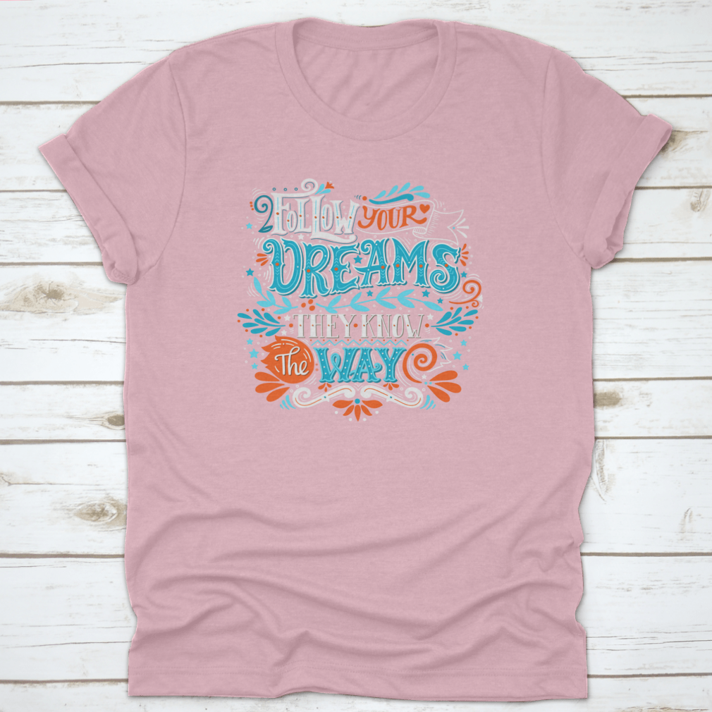 A hand-drawn inspirational quote T-shirt featuring the phrase 'Follow Your Dreams. They Know The Way' in a stylish design.