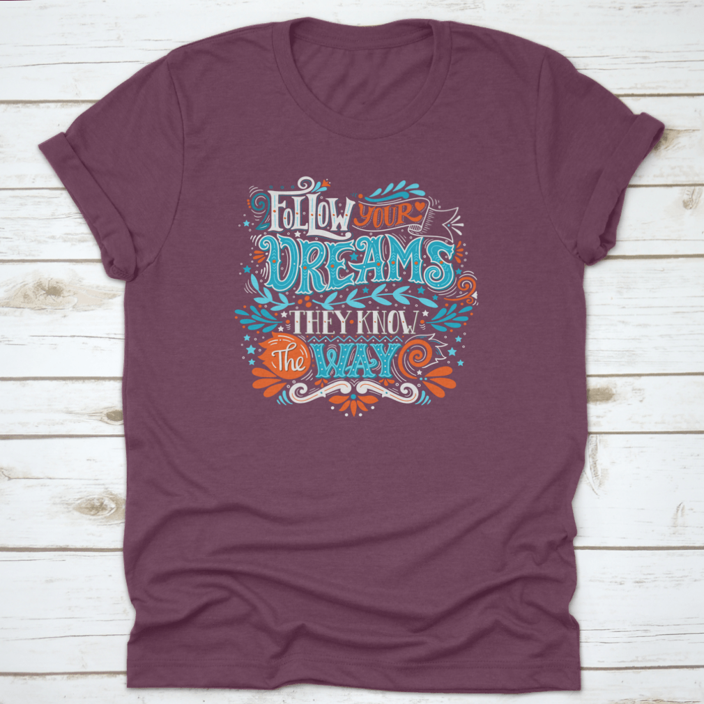 A hand-drawn inspirational quote T-shirt featuring the phrase 'Follow Your Dreams. They Know The Way' in a stylish design.