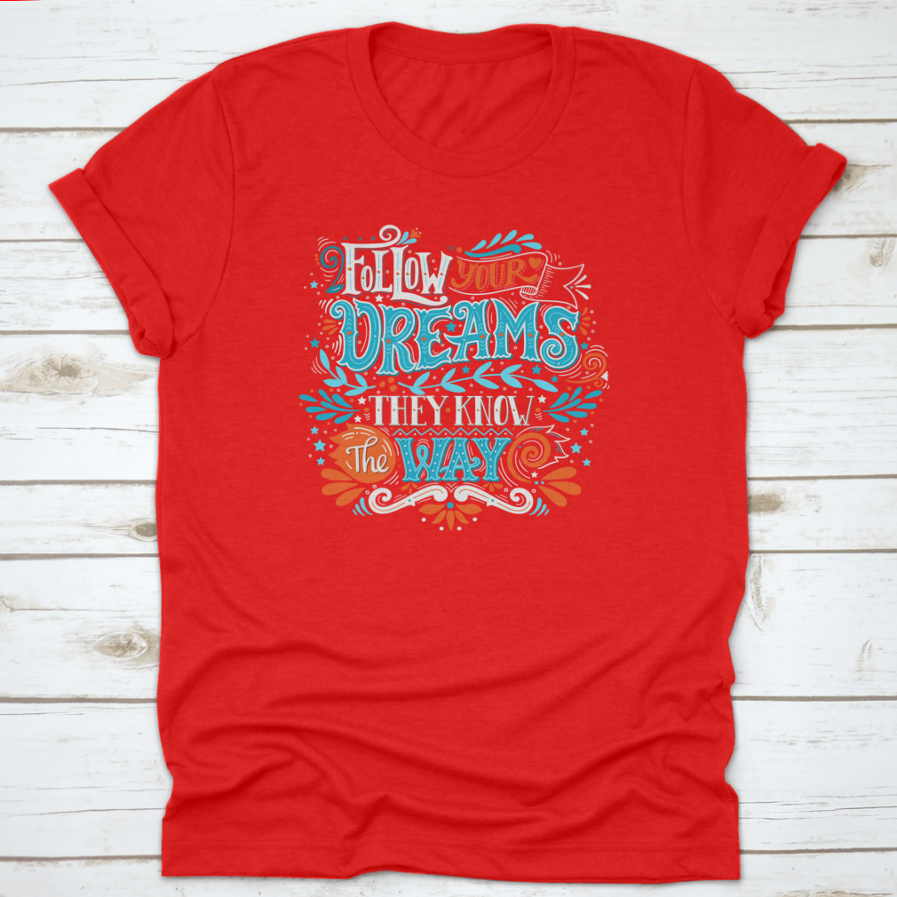 A hand-drawn inspirational quote T-shirt featuring the phrase 'Follow Your Dreams. They Know The Way' in a stylish design.