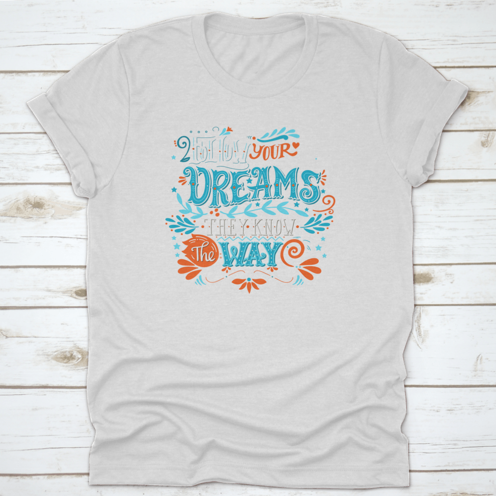 A hand-drawn inspirational quote T-shirt featuring the phrase 'Follow Your Dreams. They Know The Way' in a stylish design.