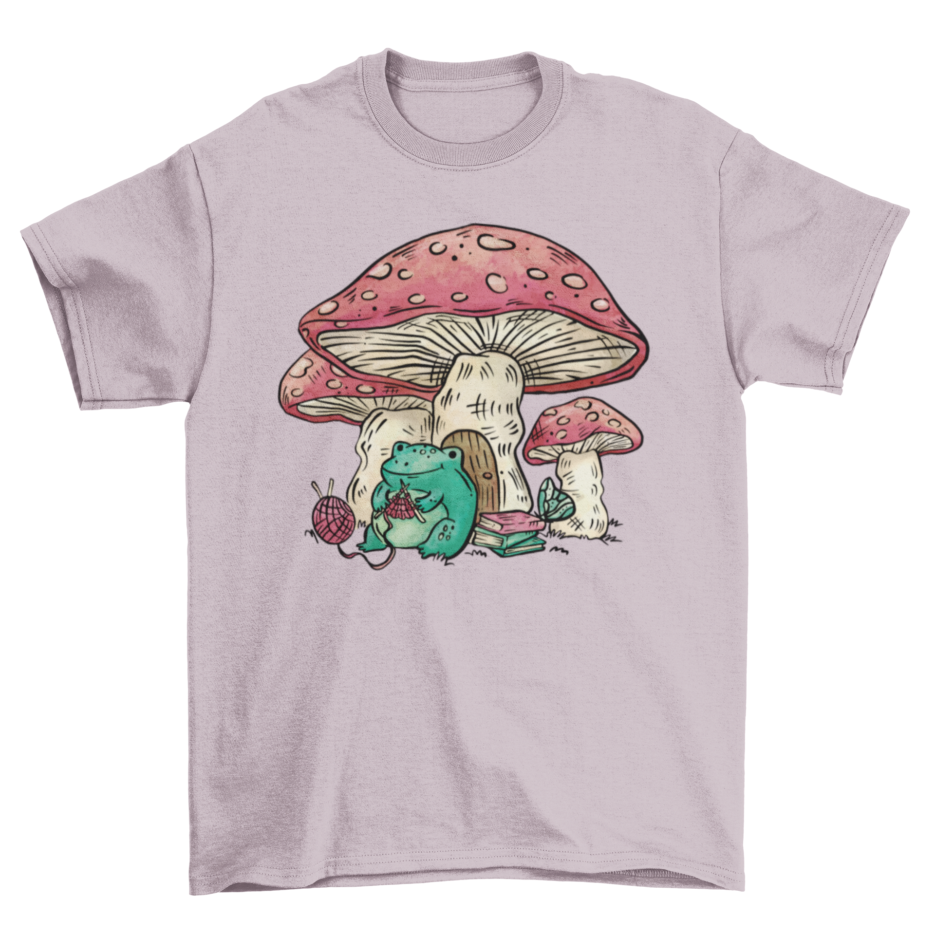 A whimsical t-shirt featuring a cheerful frog knitting next to a colorful mushroom house.