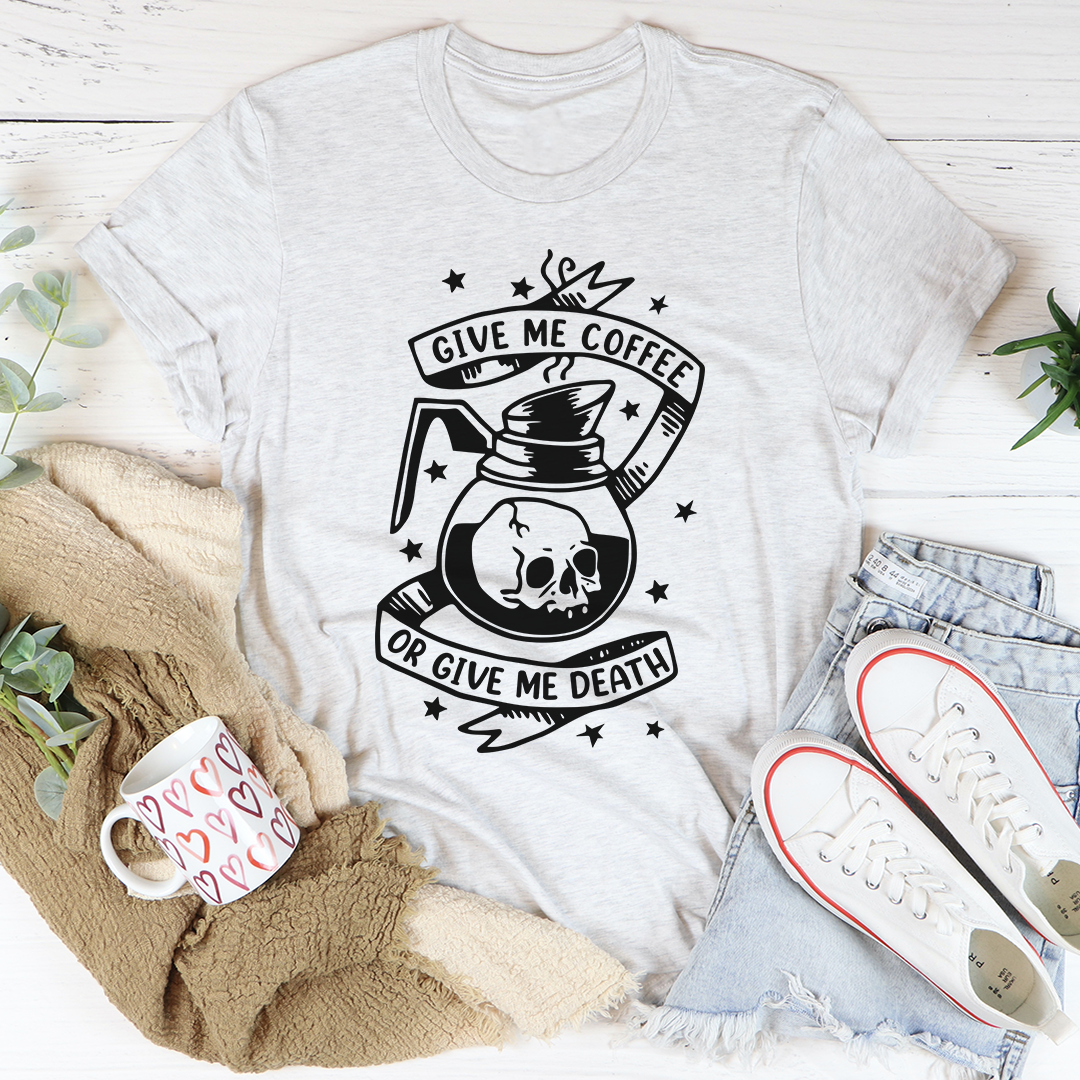 A black t-shirt with the phrase 'Give Me Coffee Or Give Me Death' printed in bold white letters, showcasing a casual and humorous design.