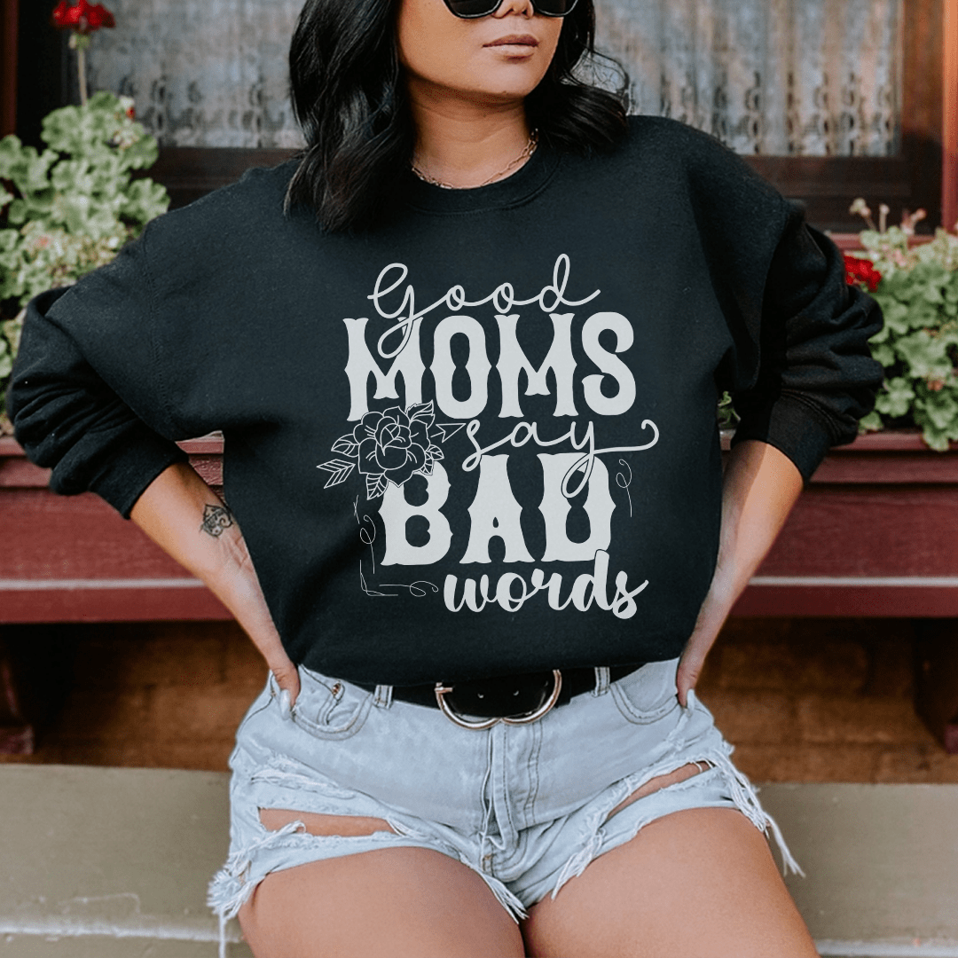 A cozy hoodie featuring the phrase 'Good Moms Say Bad Words', designed by top artists, showcasing a stylish and comfortable fit.