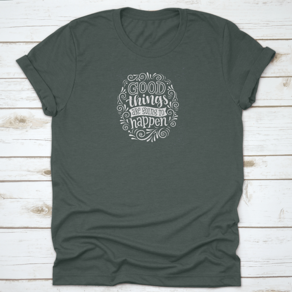 A motivational quote t-shirt featuring the phrase 'Good Things Are Going To Happen', made from 100% cotton, displayed on a neutral background.