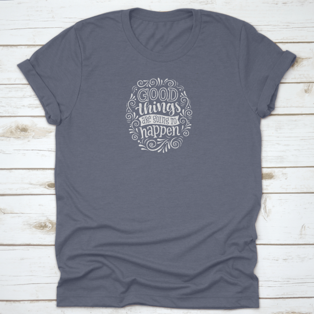 A motivational quote t-shirt featuring the phrase 'Good Things Are Going To Happen', made from 100% cotton, displayed on a neutral background.