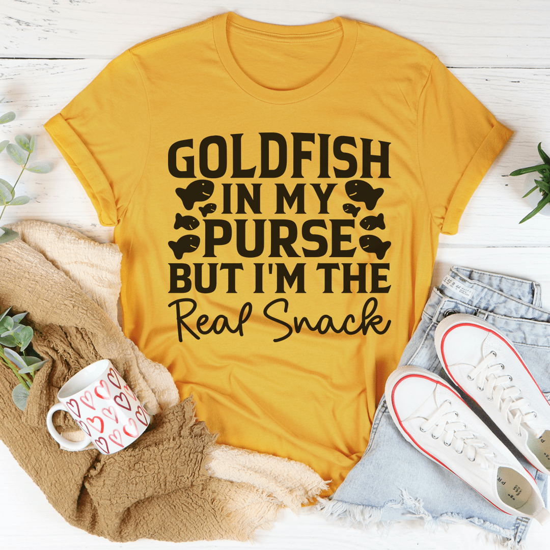 A playful t-shirt featuring a goldfish graphic with the text 'Goldfish In My Purse But I'm The Real Snack', made from soft cotton.