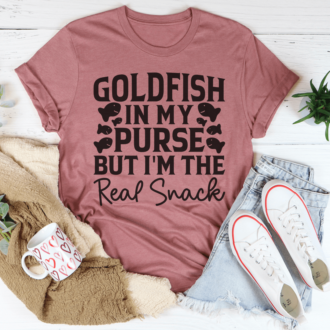 A playful t-shirt featuring a goldfish graphic with the text 'Goldfish In My Purse But I'm The Real Snack', made from soft cotton.