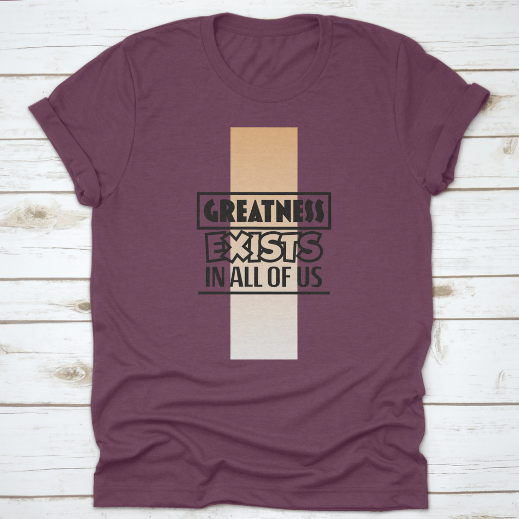 A stylish t-shirt featuring the motivational quote 'Greatness Exists In All Of Us', made from soft cotton fabric.