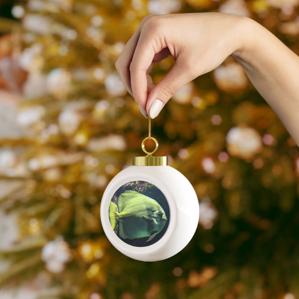 A beautiful green fish-themed Christmas ball ornament with a glossy finish and gold ribbon, perfect for holiday decorating.