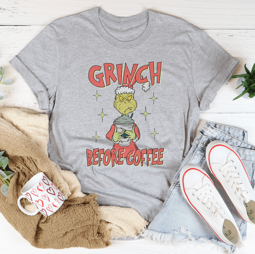 Grinch Before Coffee Tee featuring a festive design, made from 100% soft cotton, perfect for holiday celebrations.