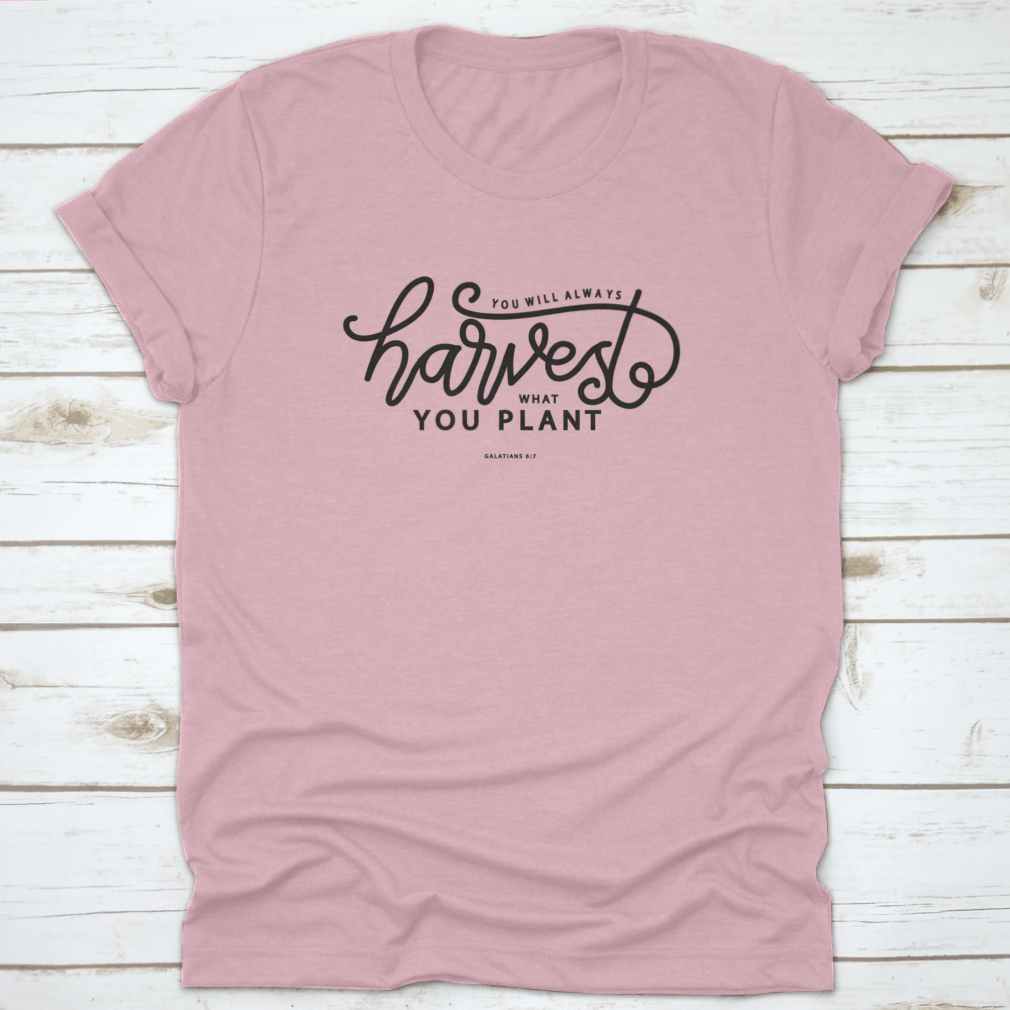 A stylish white t-shirt featuring hand lettering that says 'You Will Always Harvest What You Plant', showcasing its unique design and quality fabric.