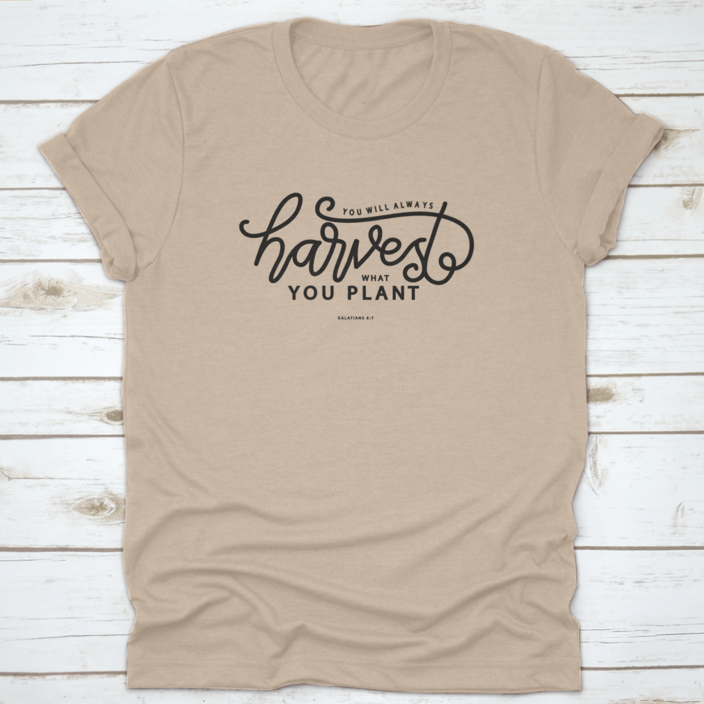 A stylish white t-shirt featuring hand lettering that says 'You Will Always Harvest What You Plant', showcasing its unique design and quality fabric.
