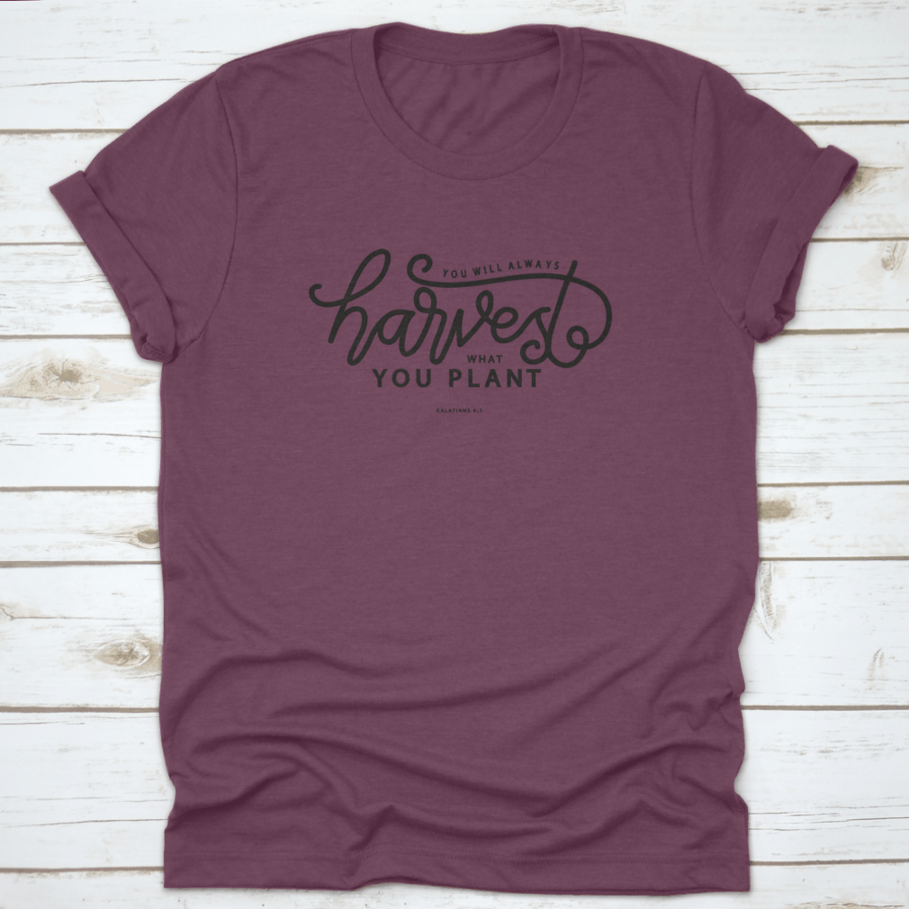 A stylish white t-shirt featuring hand lettering that says 'You Will Always Harvest What You Plant', showcasing its unique design and quality fabric.