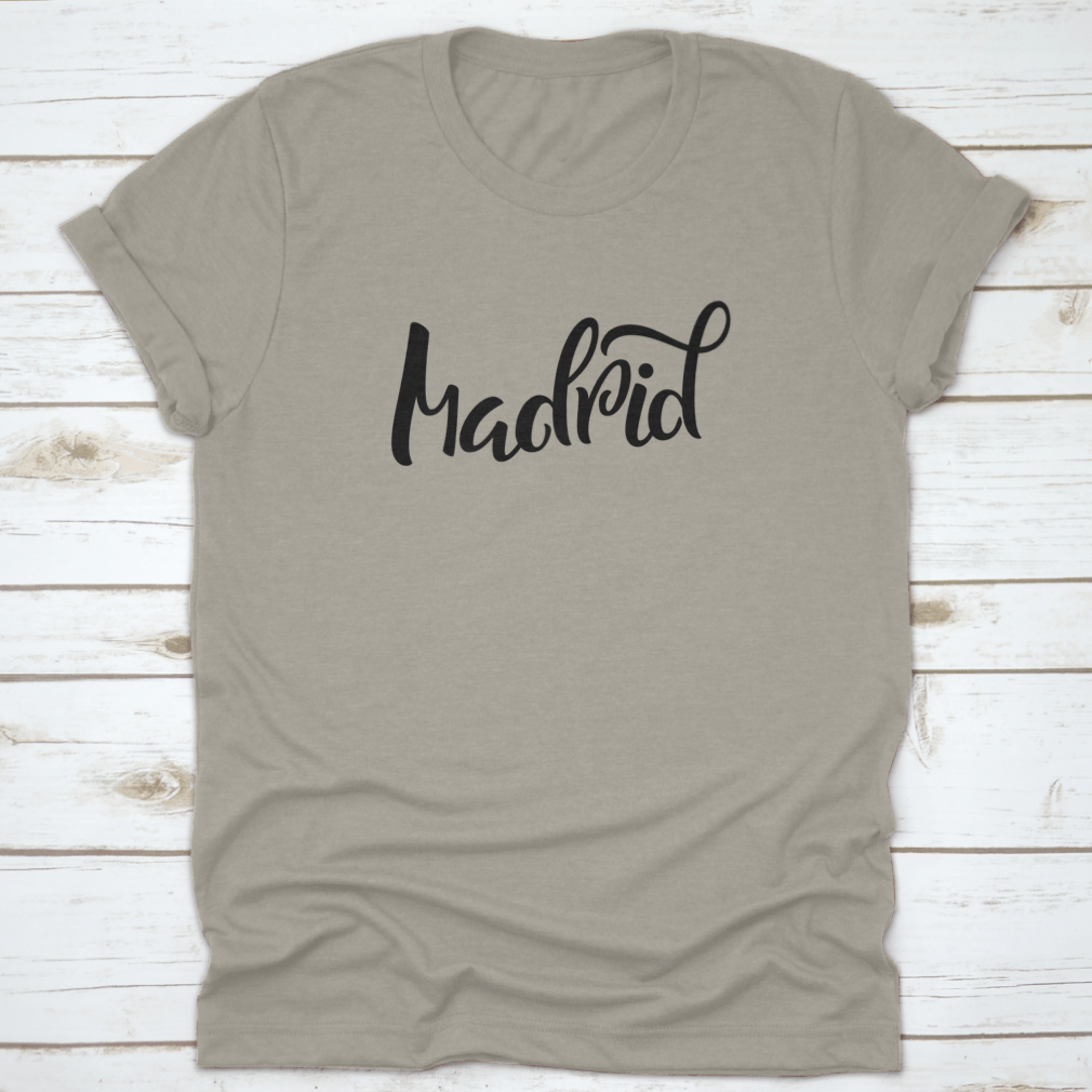A stylish t-shirt featuring hand-lettered calligraphy of Madrid, showcasing vibrant colors and a comfortable fit.