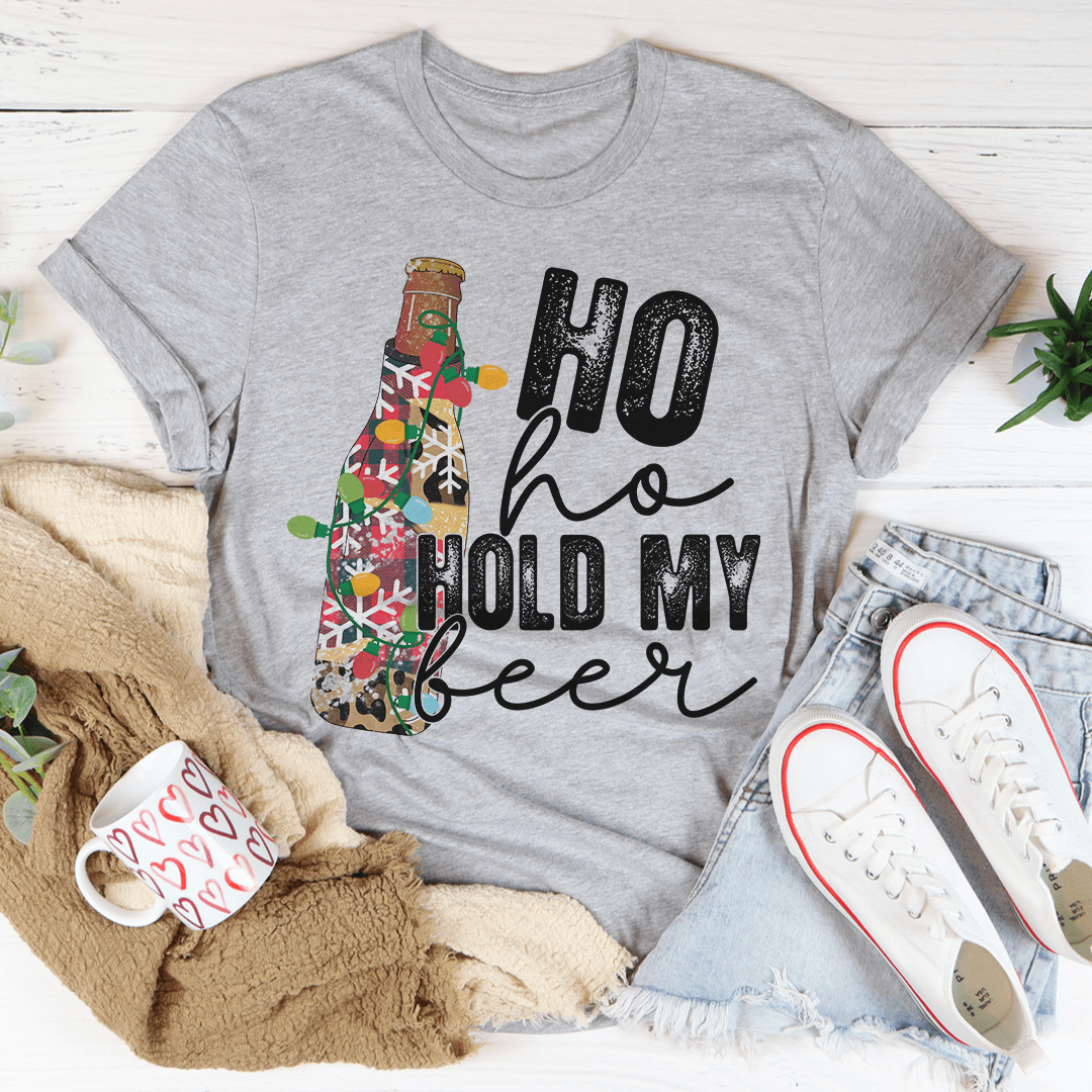 A festive Ho Ho Hold My Beer Tee made from 100% soft cotton, featuring a playful Christmas-themed design, perfect for holiday celebrations.
