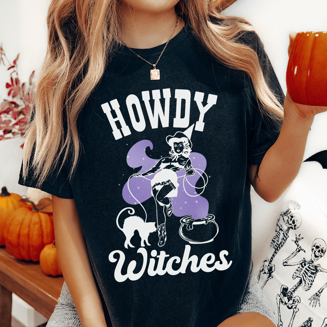A stylish Howdy Witches Tee featuring vibrant Halloween-themed graphics, made from 100% soft cotton for comfort.
