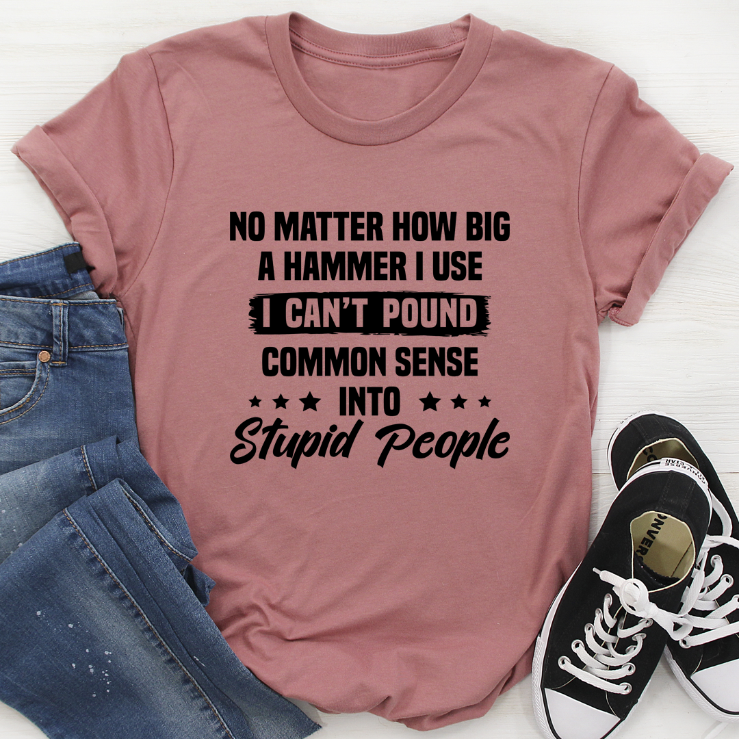 A humorous t-shirt featuring the phrase 'I Can't Pound Common Sense Into Stupid People', made from soft cotton with double stitching.