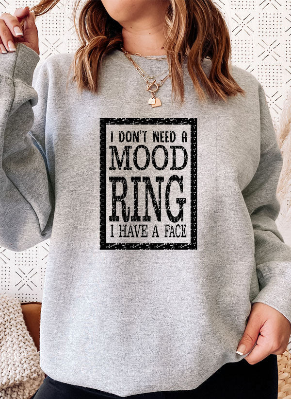 A cozy sweatshirt featuring the phrase 'I Don't Need A Mood Ring I HAVE A FACE' in a stylish font, perfect for casual wear.