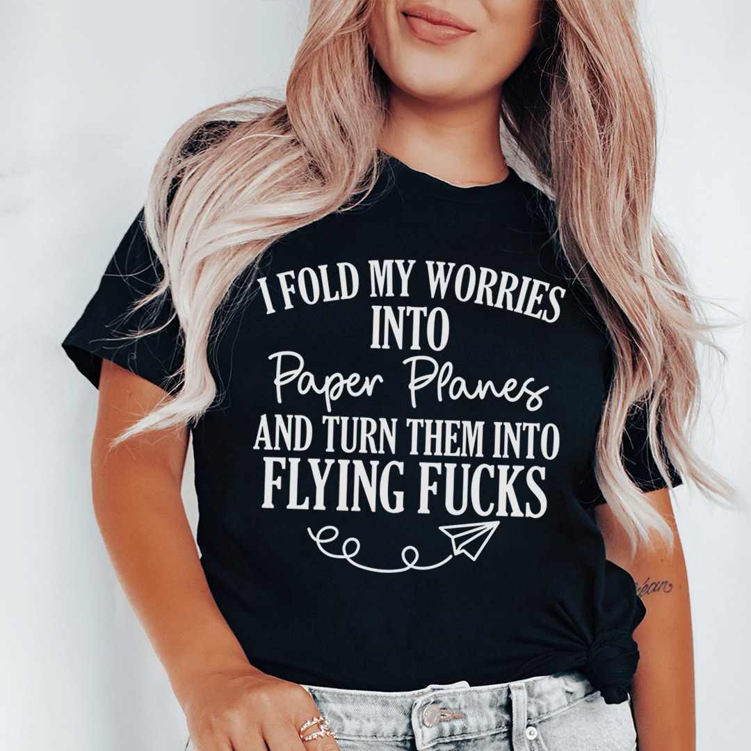 A soft, durable t-shirt featuring the phrase 'I Fold My Worries Into Paper Planes' in a stylish design, perfect for casual wear.