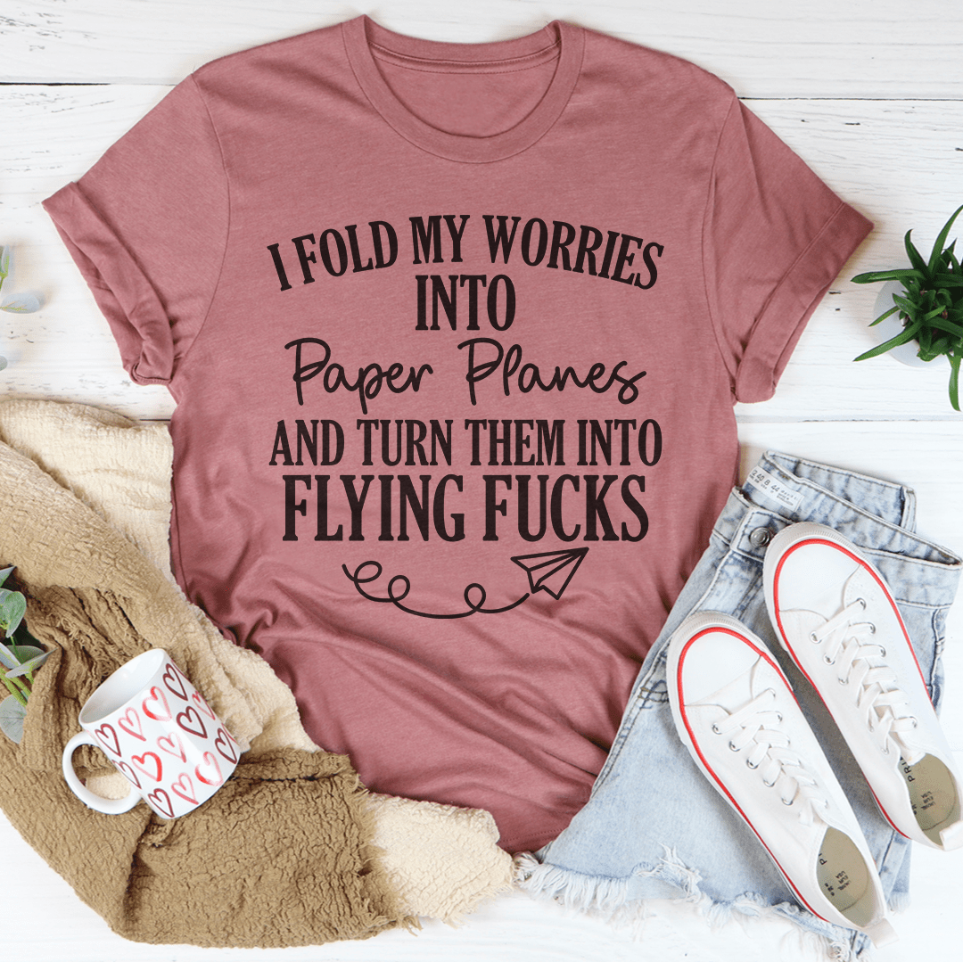A soft, durable t-shirt featuring the phrase 'I Fold My Worries Into Paper Planes' in a stylish design, perfect for casual wear.