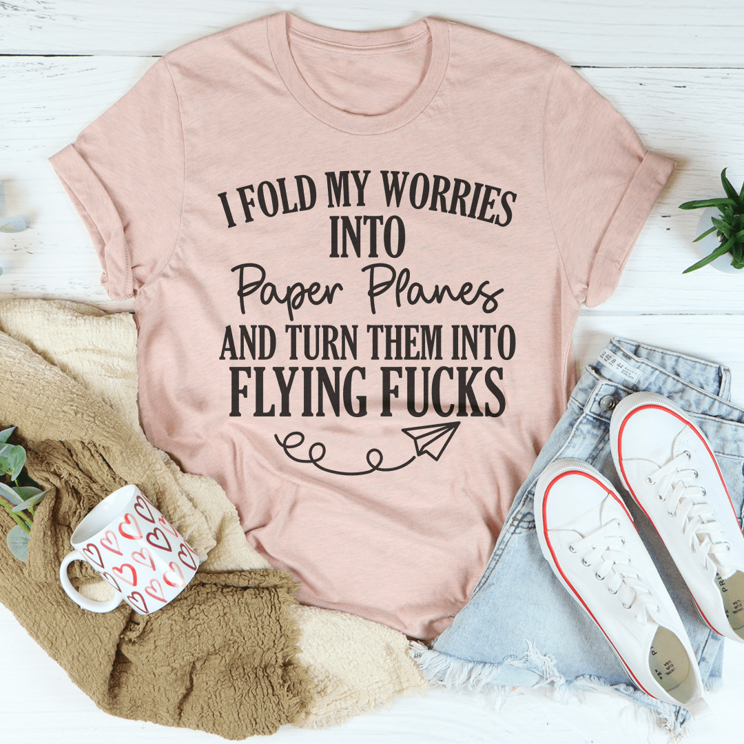 A soft, durable t-shirt featuring the phrase 'I Fold My Worries Into Paper Planes' in a stylish design, perfect for casual wear.