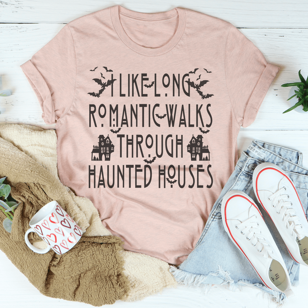 A black Halloween tee featuring the phrase 'I Like Long Romantic Walks Through Haunted Houses' in vibrant colors, made from soft cotton.