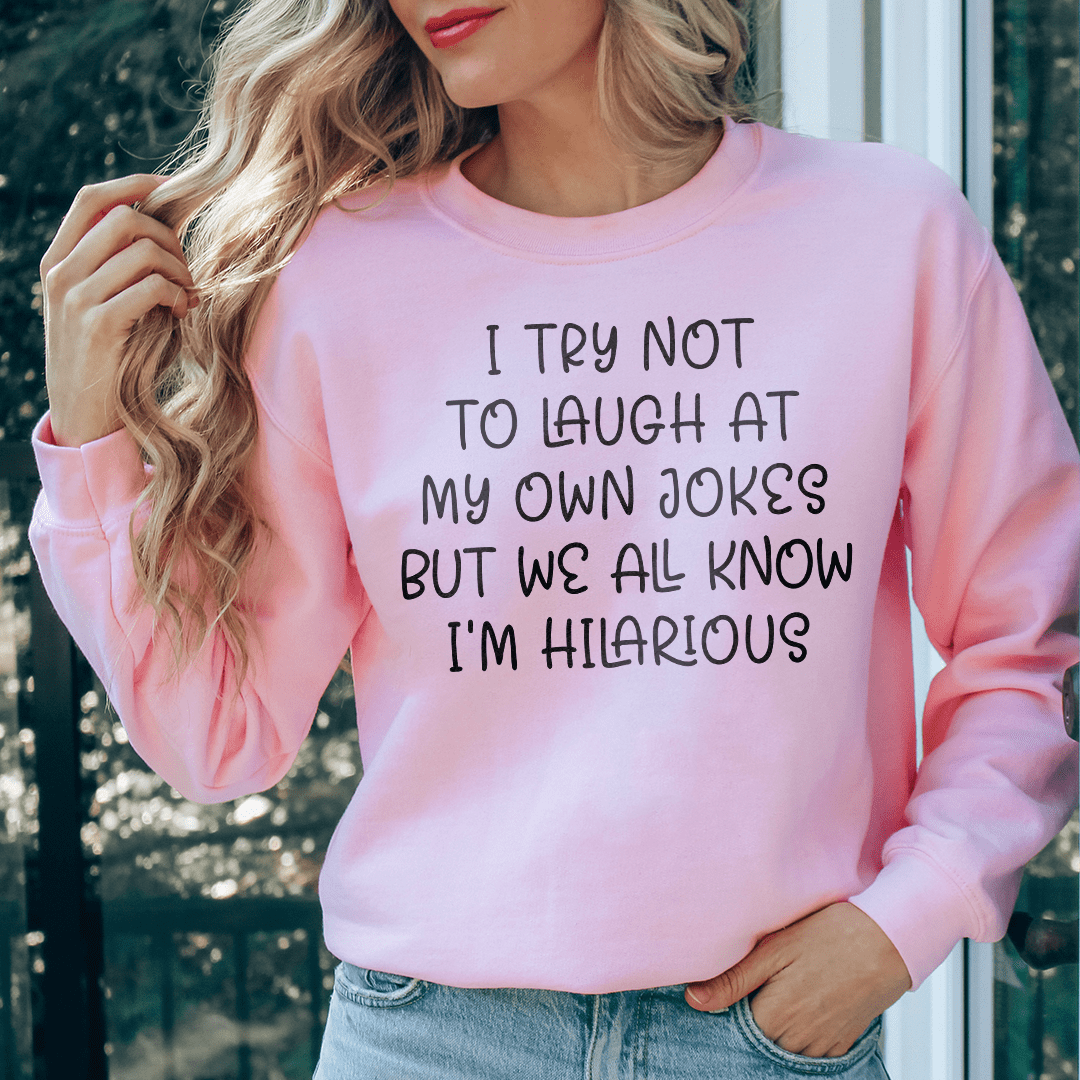 A cozy sweatshirt featuring the phrase 'I Try Not To Laugh At My Own Jokes', designed for comfort and style.