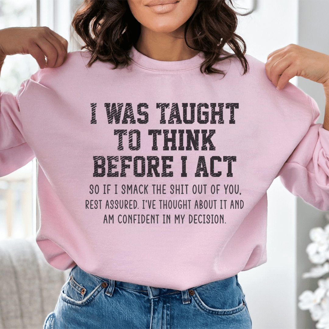 A cozy hoodie featuring the phrase 'I Was Taught To Think Before I Act', designed by top artists, showcasing a stylish and comfortable fit.