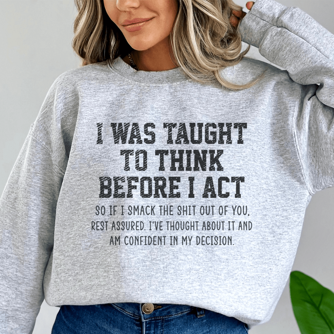A cozy hoodie featuring the phrase 'I Was Taught To Think Before I Act', designed by top artists, showcasing a stylish and comfortable fit.