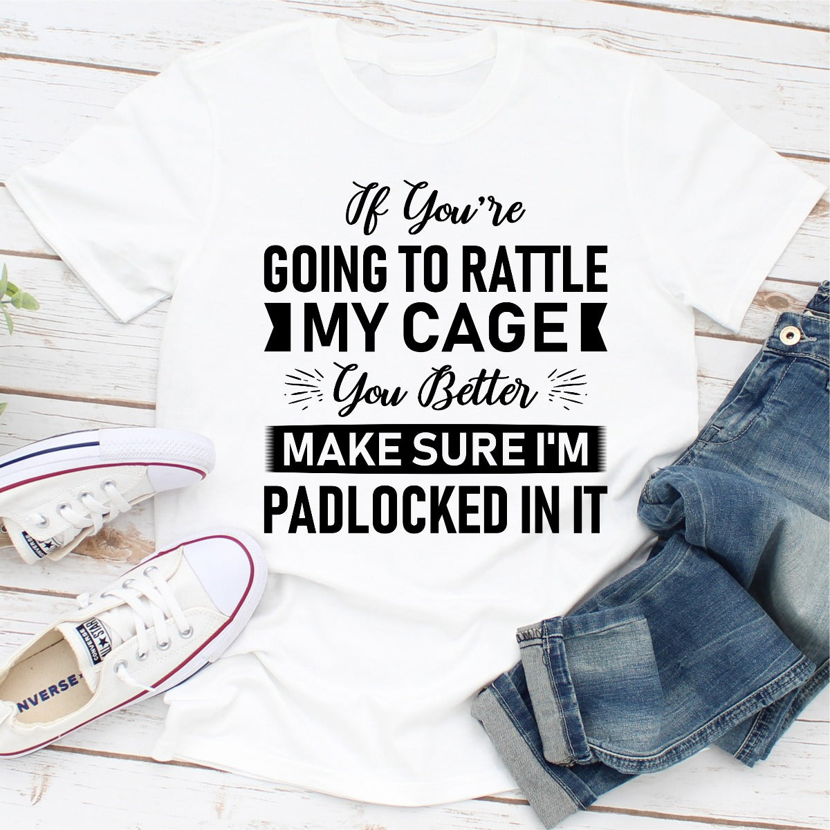 A stylish black t-shirt featuring the phrase 'If You're Going To Rattle My Cage You Better Make Sure I'm Padlocked' printed in bold letters.