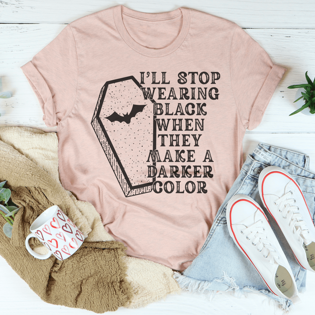 A black Halloween tee featuring the phrase 'I'll Stop Wearing Black When They Make A Darker Color' in vibrant print, made from 100% soft cotton.