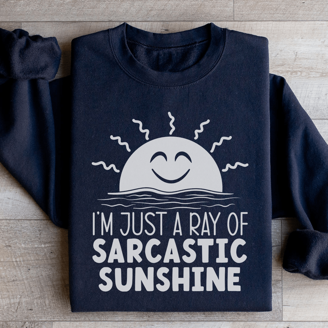 A cozy sweatshirt featuring the phrase 'I'm Just A Ray Of Sarcastic Sunshine' in a stylish font, perfect for casual wear.