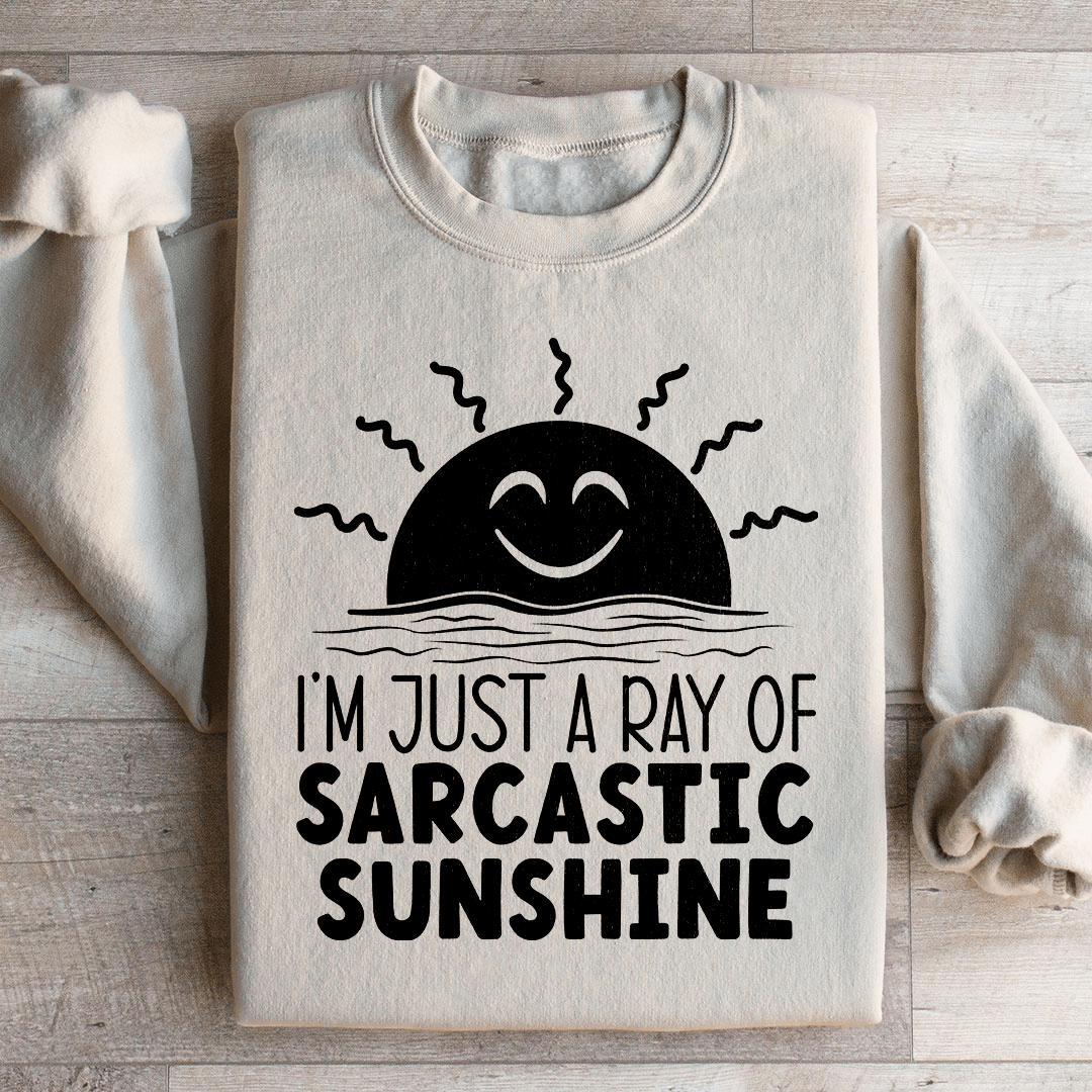 A cozy sweatshirt featuring the phrase 'I'm Just A Ray Of Sarcastic Sunshine' in a stylish font, perfect for casual wear.