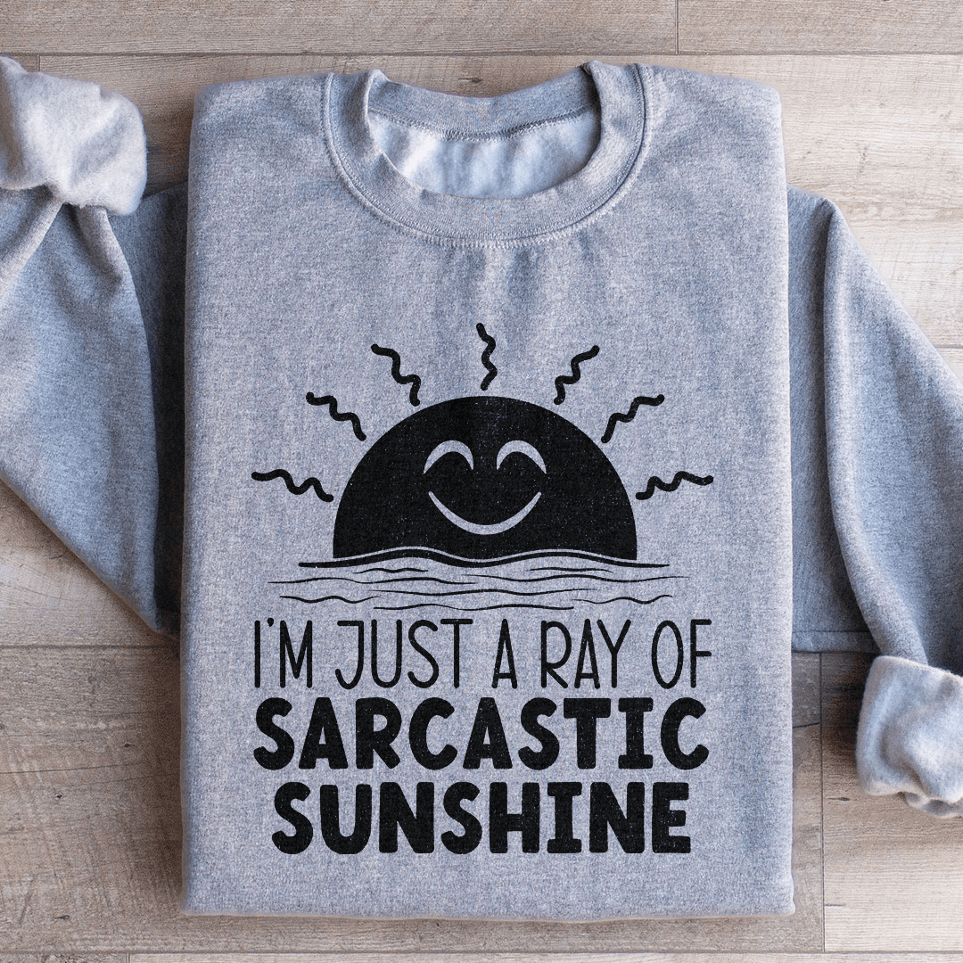 A cozy sweatshirt featuring the phrase 'I'm Just A Ray Of Sarcastic Sunshine' in a stylish font, perfect for casual wear.
