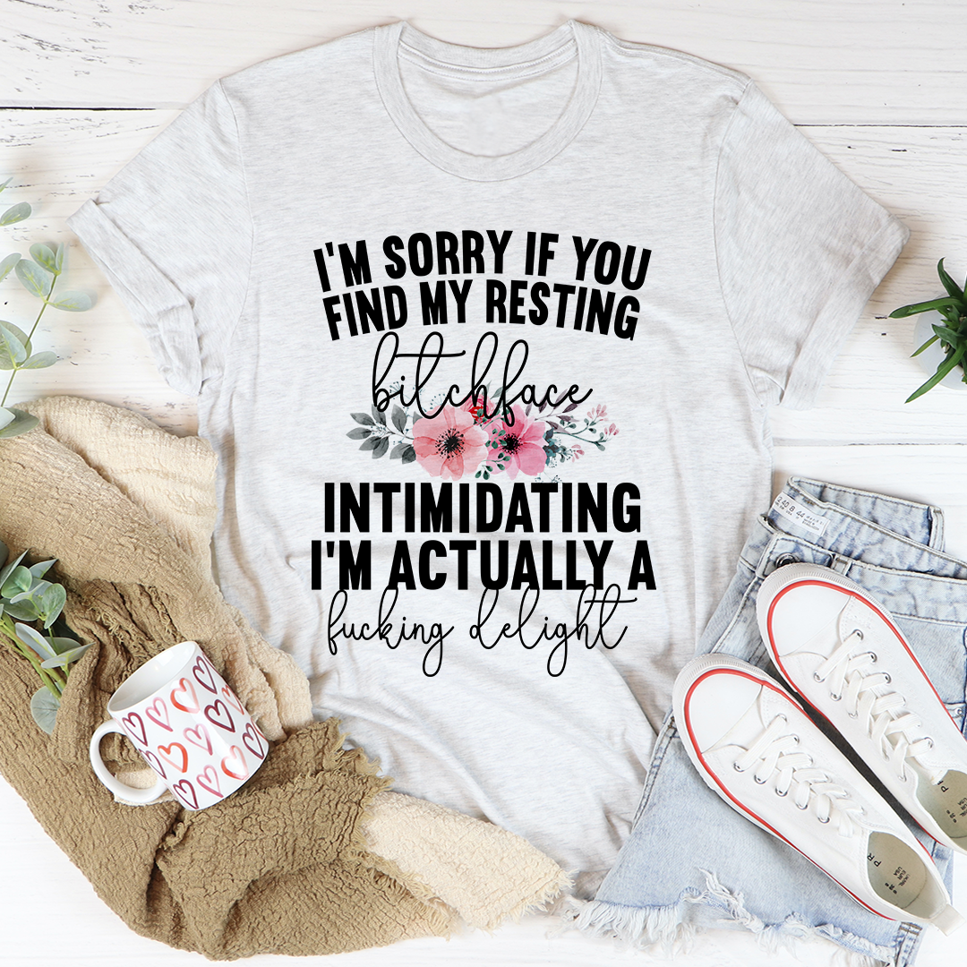 A humorous t-shirt featuring the phrase 'I'm Sorry If You Find My Resting Face Intimidating', made from soft cotton with double stitching.